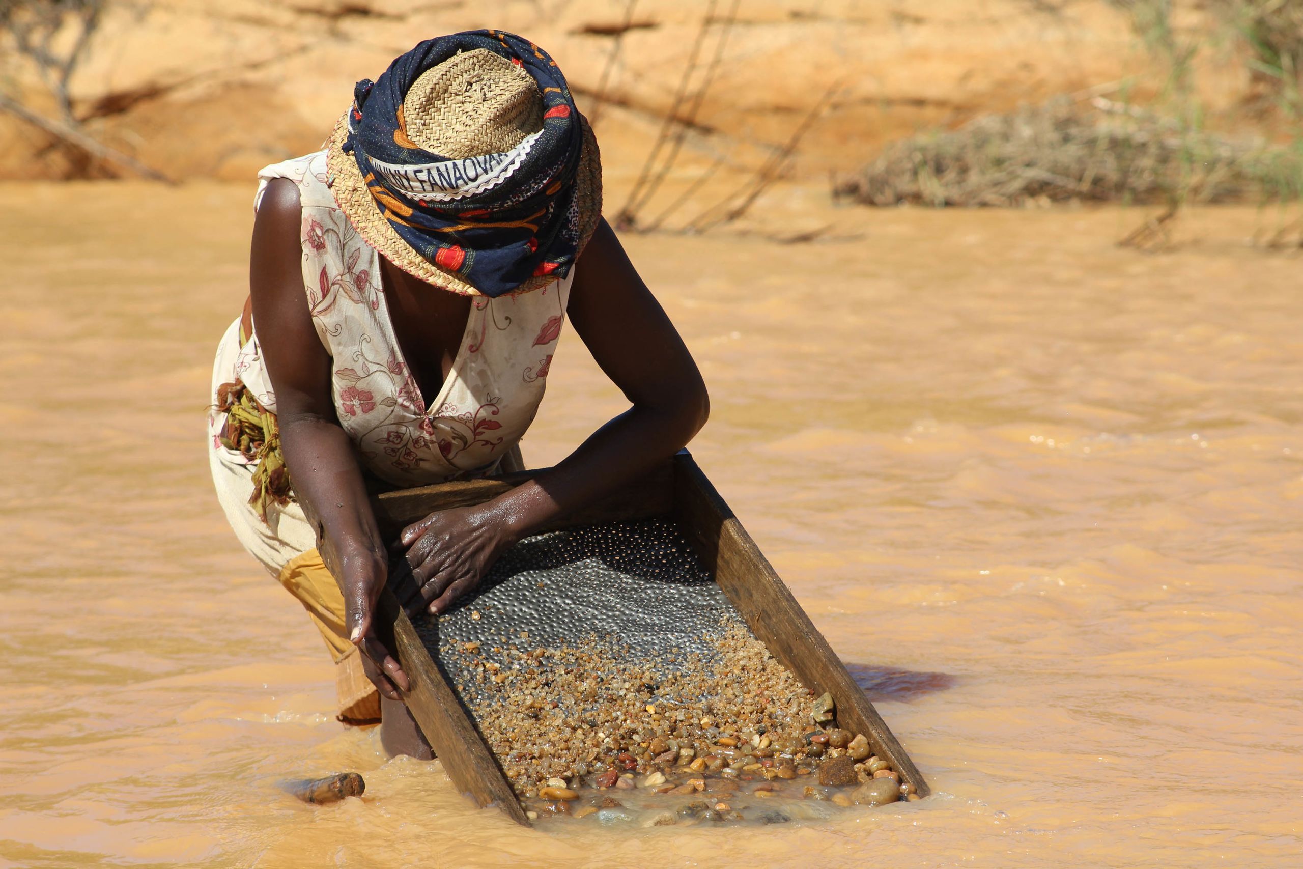 Malagasy woman sieving for sapphires