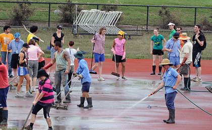 Volunteers help clean up the UQ Athletics Centre at St Lucia following the floods