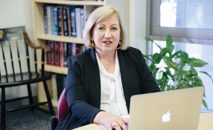 Professor Jennifer Stow sitting at a desk in front of a laptop