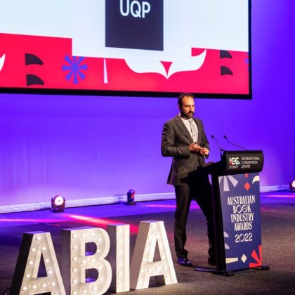 Ben James from UQP standing at a podium at the ABIA awards accepting UQP's award