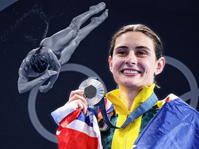 Maddison Keeney holding a silver Olympic medal and smiling with an Australian flag around her shoulders