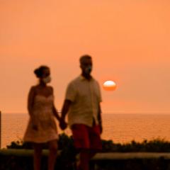 Two people standing beneath a smoggy orange sky