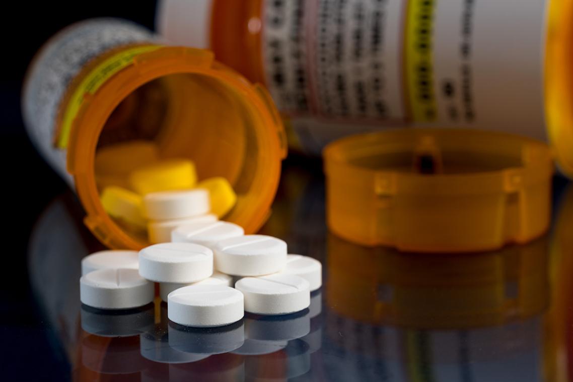 A bottle of prescription medication lying on its side with the pills spilling out 